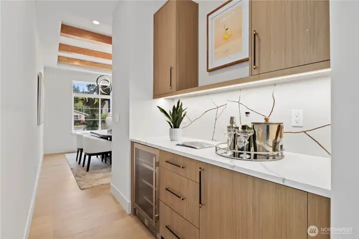 Butler’s pantry with beverage fridge, quartz countertop, statement backsplash detail including under cabinet lighting.