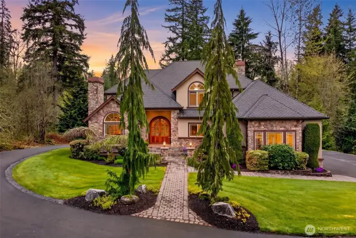 Pull through the sweeping circular drive at dusk and feel the day melt away as warm window light, towering evergreens, and a storybook stone facade welcome you home. A true private retreat tucked into nearly 4.6 acres of natural Pacific Northwest beauty.