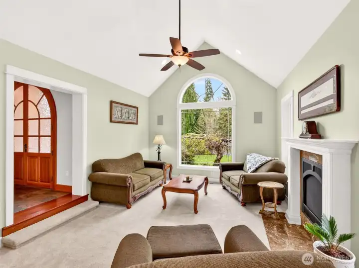 Bathed in natural light from the arched picture window, the formal living room offers a serene gathering space anchored by a gas fireplace and finished with built-in surround sound. Just steps from the grand foyer, it sets a gracious tone for the entire home.