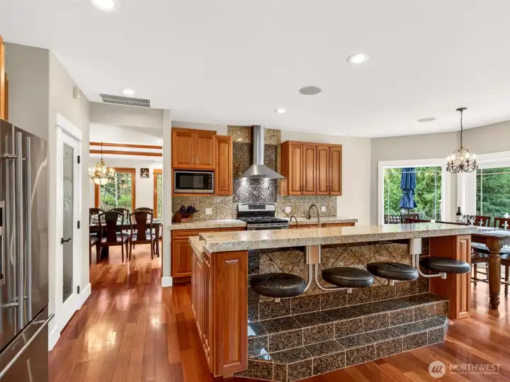 The kitchen flows openly to the breakfast nook on one side and formal dining on the other, anchored by a tiered island with bar seating for four. A central hub designed to keep everyone connected, no matter the occasion.