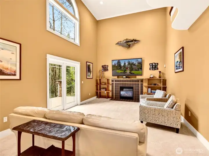 Soaring two-story ceilings and a tiled gas fireplace anchor the family room, while sliding glass doors open to the back patio for effortless indoor-outdoor living. A bright, airy gathering space built for relaxed everyday moments.