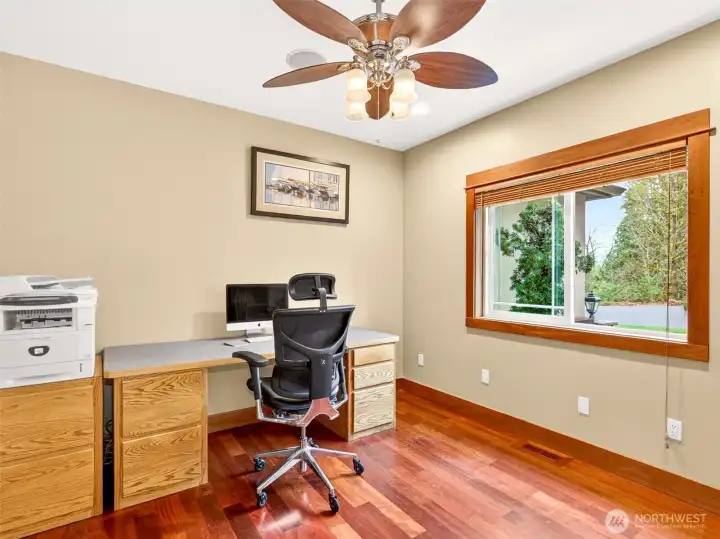 A dedicated main-level office with rich Brazilian cherry hardwoods, ceiling speakers, and a tranquil window view offers the perfect work-from-home retreat. Quiet, productive, and steps from the heart of the home.