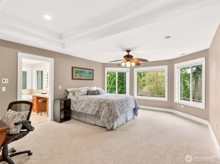 The expansive primary suite is your private sunset sanctuary, featuring a tray ceiling, sweeping windows with treetop views, and direct access to the spa-inspired bath. A retreat designed for rest and renewal.