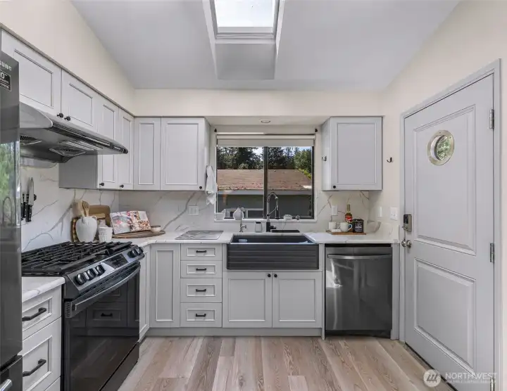 The updated chef’s kitchen offers stunning quartz counters, custom cabinets, & SS appliances