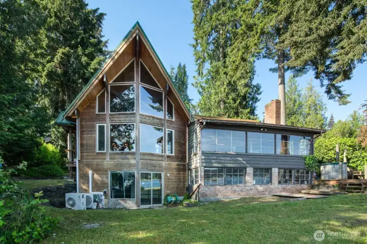 Ship Prow Cedar home is about 15 years old, right next to it is the original 1942 Cabin. Footprint of Cabin allows you major dream home potential--renovation, building anew, all because of the grandfathered in floor plan