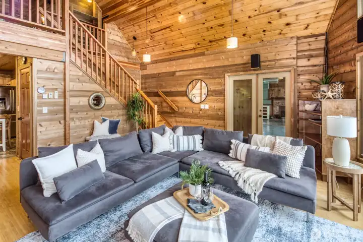 Great Room showing stairway to lofted Primary Suite and French doors allowing entrance into original cabin.