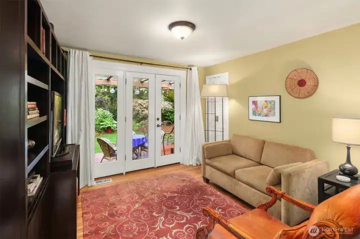 tv room leading to covered deck and lush back yard