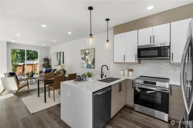 Spacious open-concept kitchen and living area with modern lighting and a sleek, minimalist design.