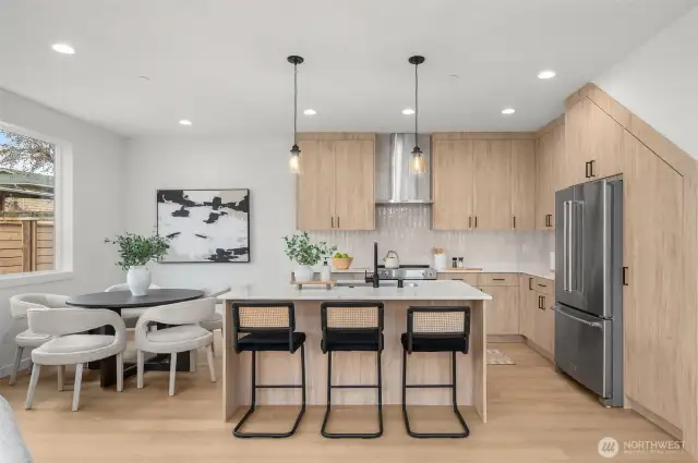 Say hello to your statement kitchen. With quartz counters, warm flat-panel cabinetry, designer lighting, and an island built for brunching, this kitchen is a chef’s kiss.