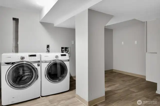 Utility room with new hot water heater and full size washer and dryer.