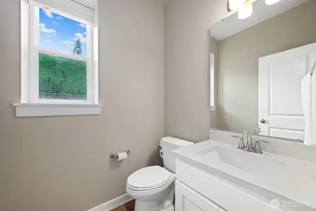 Powder room sits behind the kitchen right off the access door to the garage.