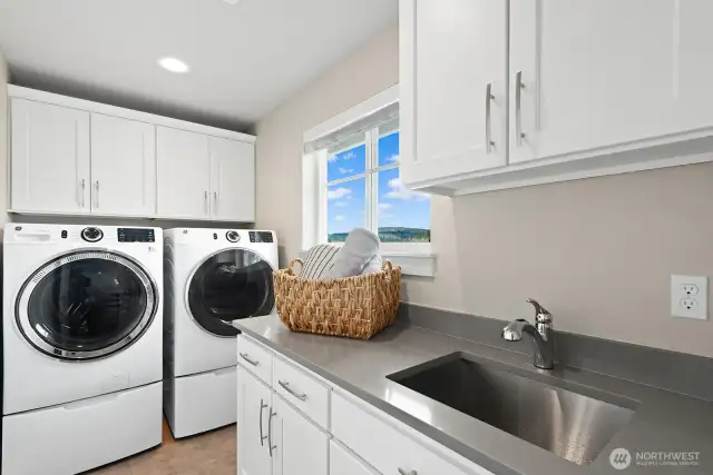 The laundry room features a sink, folding counter and custom stroage cabinetry.
