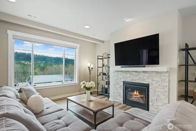 The living room features a gas fireplace with an expansive window for catching more views and black out blinds for early summer movie nights.