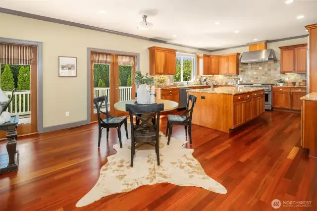 Furnish the home to your personal taste!  This is the informal eating space located between the kitchen and great room.  Notice the beautiful Brazilian Cherry Hardwood floors!  Hardwood flooring in today's construction is pre-fabricated veneer that is snapped into place on site.  Not the case here!  These solid cherry floors were installed raw and finished in place.  They are as beautiful as they are durable!