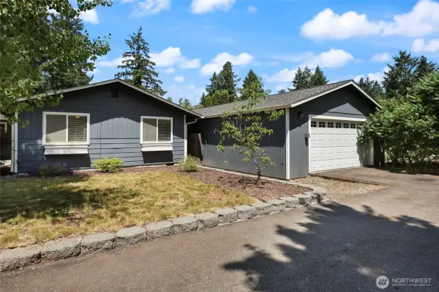 Detached garage with gate in between, leading to man door and backyard.
