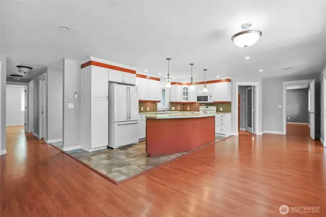 Kitchen is definitely the heart of this home, and the split floor plan is super appealing.  Primary bedroom to the right, 2 other bedrooms/bath/laundry to the left.