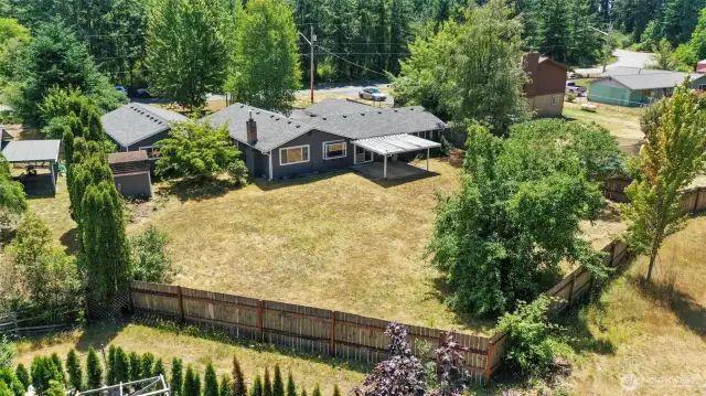 Backyard is fully fenced, with green space behind.