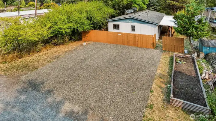 Large off-street parking area with raised garden bed ready for plants!
