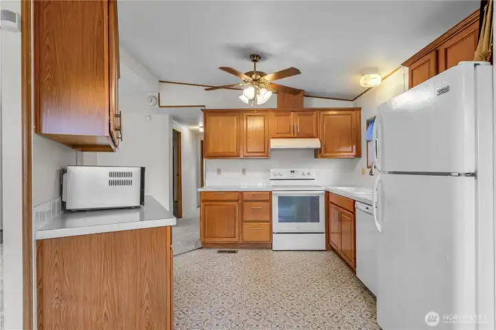 The updated kitchen includes a ceiling fan, newer vinyl flooring, and all appliances come with the home.