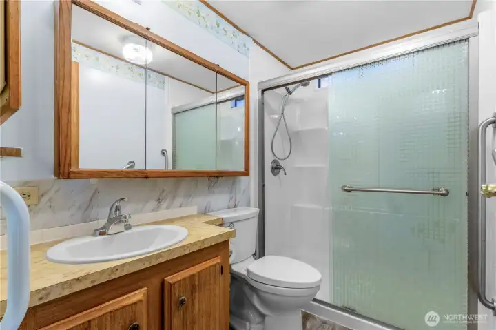 The bathroom includes an updated low step-in shower with a grab bar nearby.