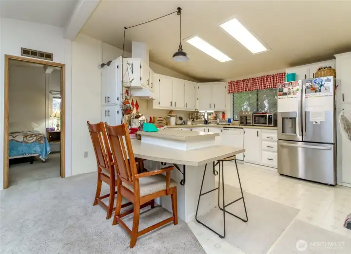 Kitchen with an eating bar and skylights. New Refrigerator, Stove, and Sink. Adjacent to the Primary Bedroom.