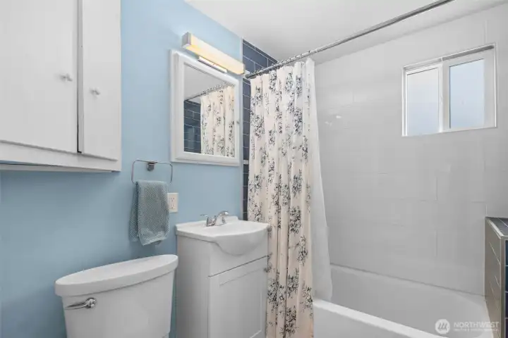 Updated bathroom with new tile, toilet, and vanity.