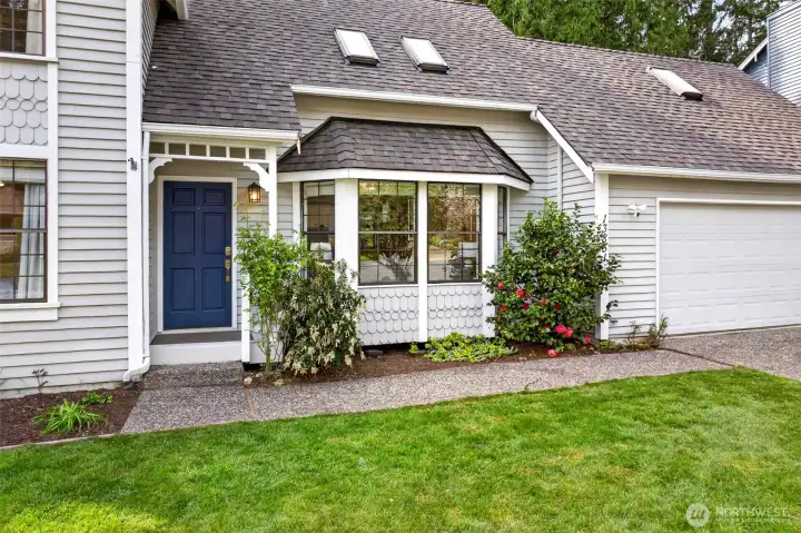 A covered entry, blooming camellias, and charming bay window detailing create an inviting welcome that sets the tone for the warmth and craftsmanship found inside.