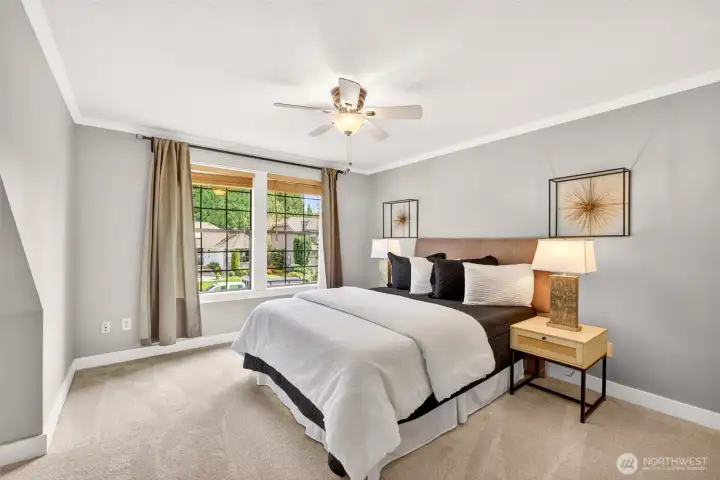 The primary suite welcomes you with crown molding, plush new carpeting, and oversized windows framing serene neighborhood views, creating a true daily retreat.