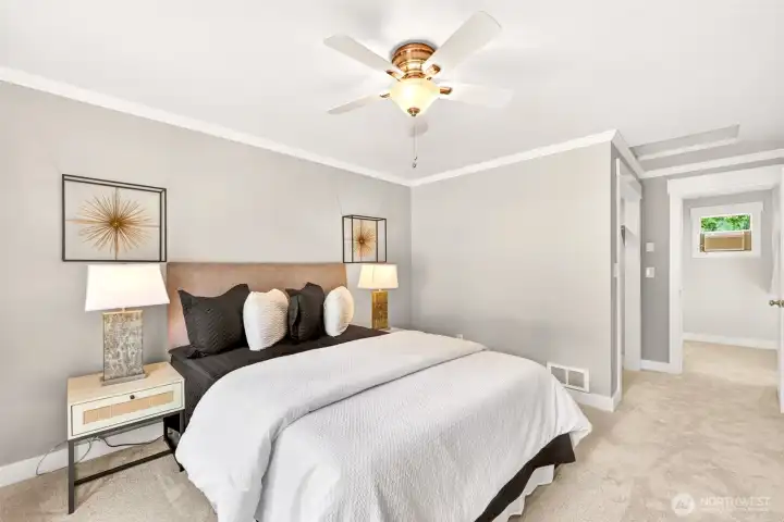 Generously proportioned with crown molding and fresh new carpet, the primary suite offers room to unwind and direct access to a walk-in closet beyond.