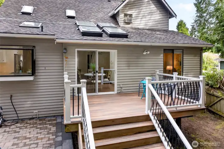 A new stone paver patio extends entertaining space below the freshly finished deck, creating a flexible outdoor living area built for gatherings, dining, and weekend relaxation.