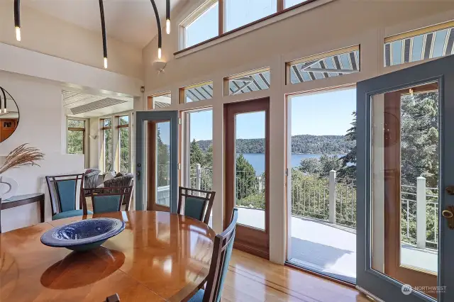 Wood framed glass doors connects to a wrap-around deck with a wall of glass to take advantage of spectacular views.