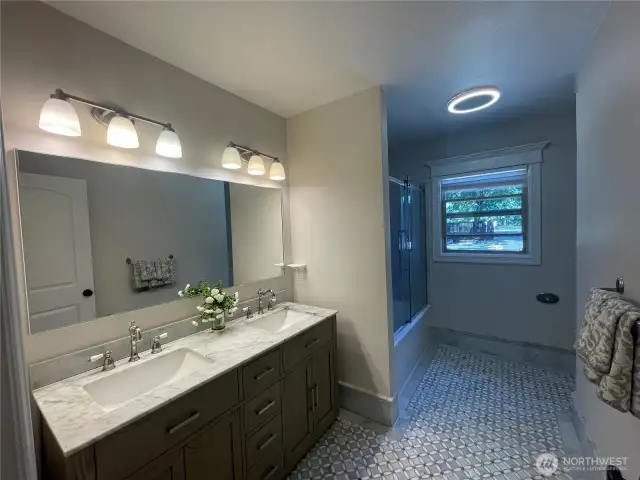 Main Level Bathroom with Marble Countertop and Floors