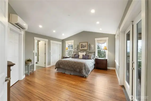Primary bedroom with vaulted ceilings, walk in closet and deck access.