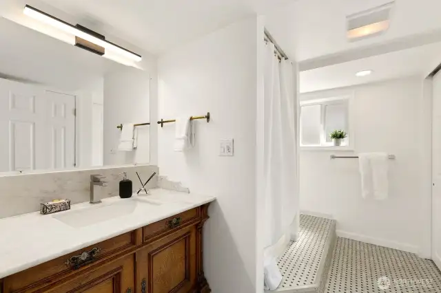 Three-quarter bath in lower level.  Antique vanity installed with new sink, Carrera marble counter tops and plenty of closet/storage space.