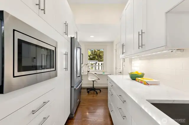 Ruvati 30" stainless sink and Custom Pure plumbed water filter.  Above custom cabinet used for storing vases then filling them conveniently below.  Hardwoods glow!