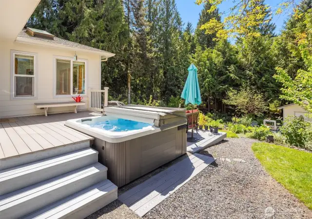 Low maintenance composite decking offers two-tiers of areas for entertaining.  Hot tub conveys.