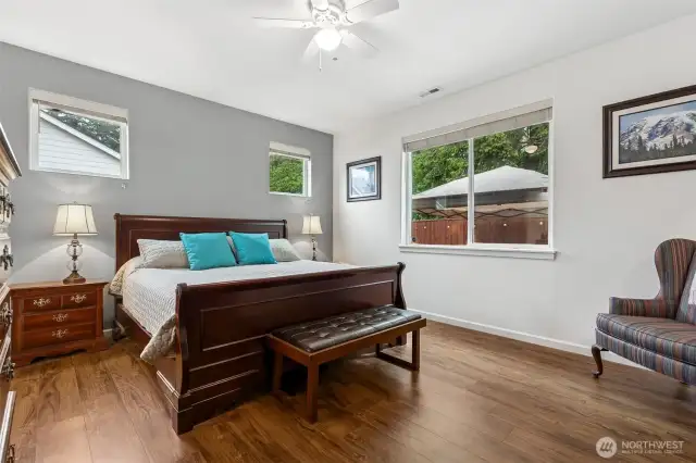 Large primary suite with laminate flooring and walk-in closet