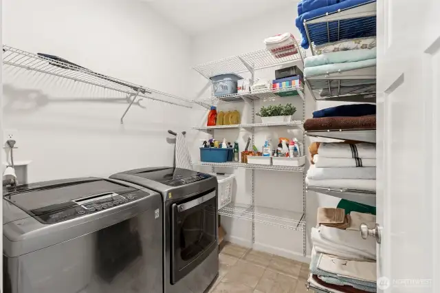 Walk-in laundry room with upgraded additional shelving installed for linens and added storage