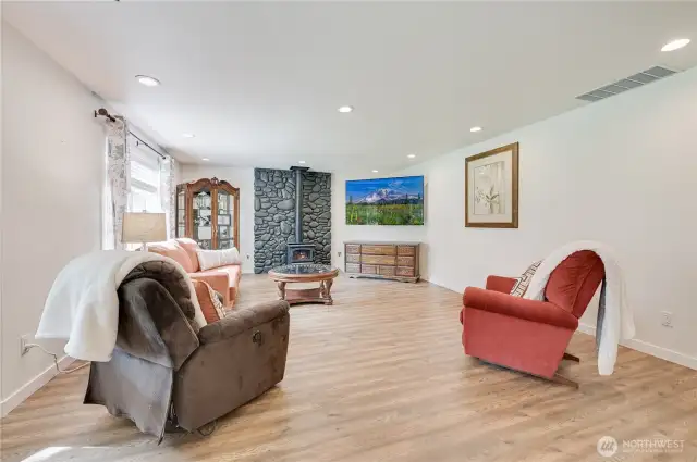 This is the family room, on the other side of the kitchen.  There is a slider to the back deck, as well as a potential for casual dining in this space.  You'll appreciate the stove on chilly evenings.