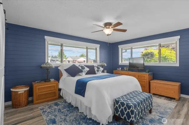 Spacious owner’s suite with dual windows for natural light * Rich navy shiplap accent wall