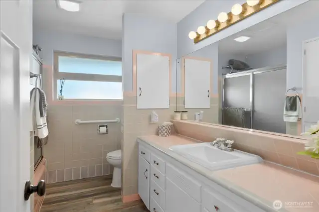 Charming vintage-style main bathroom with iconic pink &   gray tile countertop with matching trim