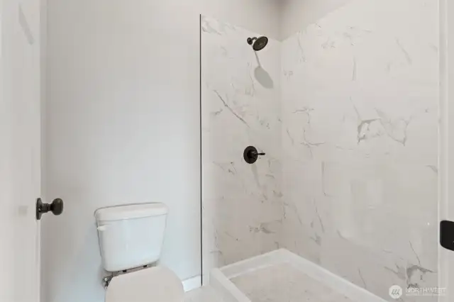 Primary bathroom shower and toilet room.