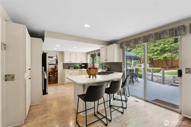 Kitchen area with breakfast bar makes keeping connected easier. With sliding door to the back deck.