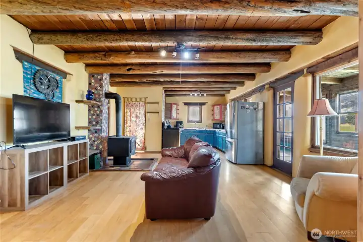 Open floor plan with kitchen, living room, and dining room situated between wings of the house.