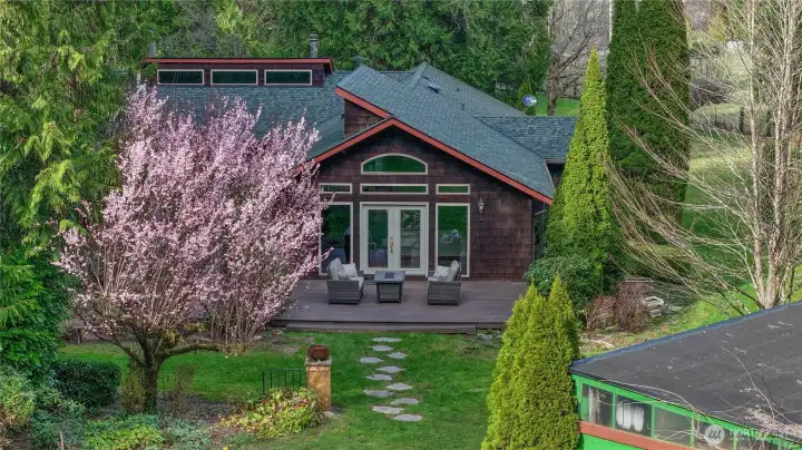 Private northwest retreat surrounded by mature trees with inviting outdoor living space.