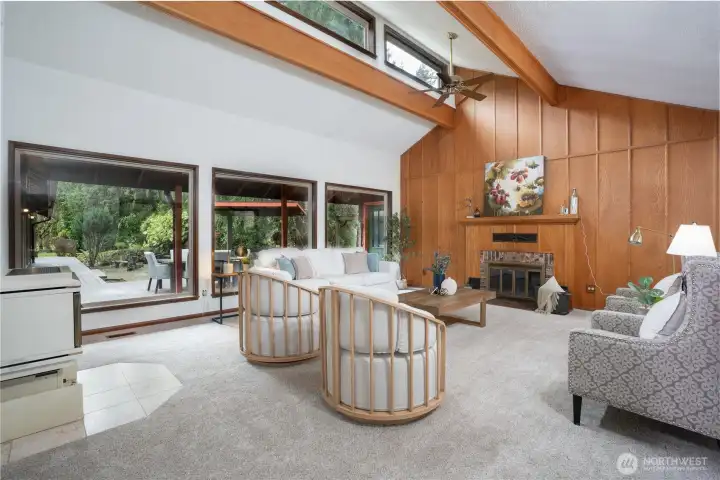 Expansive living room with vaulted ceilings, and natural light.