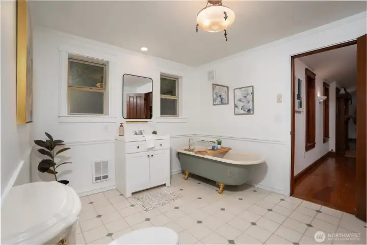 Charming, spa-inspired bathroom featuring a classic clawfoot soaking tub with elegant fixtures, creating a relaxing retreat. Bright and airy with abundant natural light, the space includes a clean vanity, timeless tile flooring, and tasteful finishes throughout. A perfect blend of character and comfort for everyday use or unwinding at the end of the day.