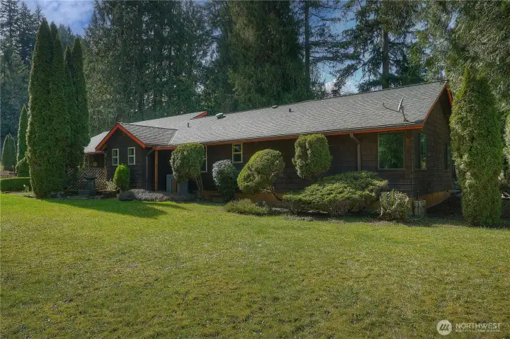 Charming Northwest-style home set on a beautifully manicured, park-like lot with mature evergreens and expansive usable lawn.