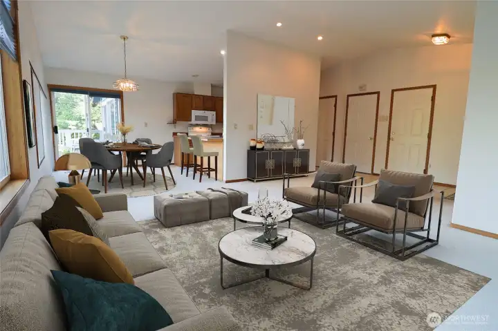 A wide view of the main living area, virtually staged, showing how the open layout takes in water and mountain views from nearly every angle.
