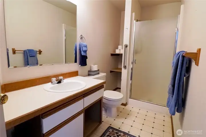 A second bathroom, ensuite for the primary bedroom, featuring a glass shower door.